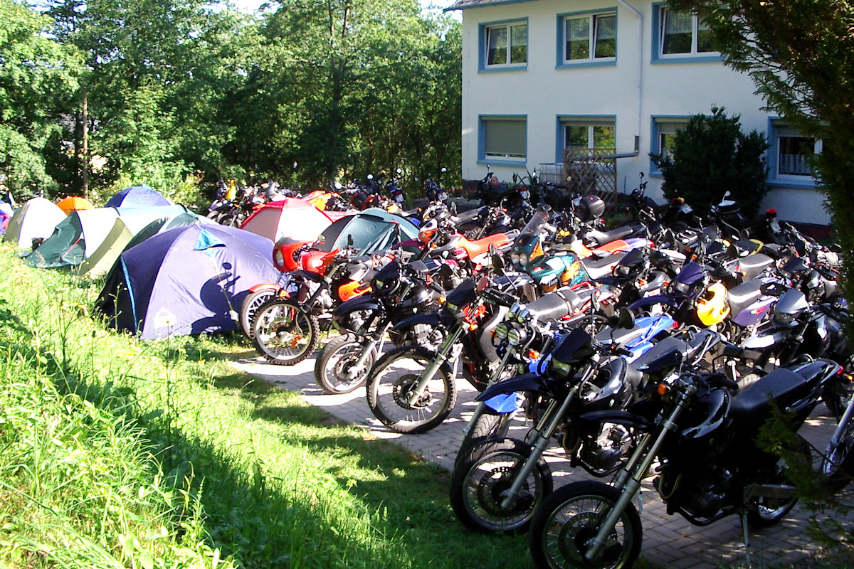 Zelte und Motorräder vor dem Haus