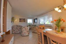 Wohnzimmer mit Couch, TV, Esstisch